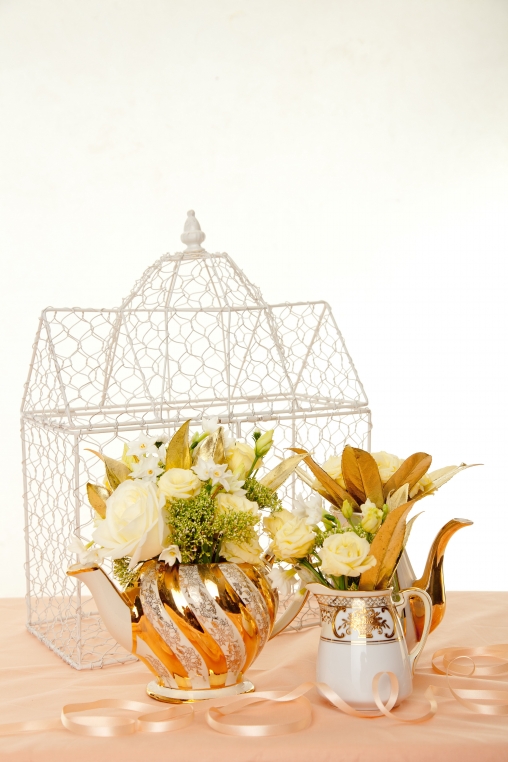 Think lots of cream and white flowers adorned with gold accents and spilling