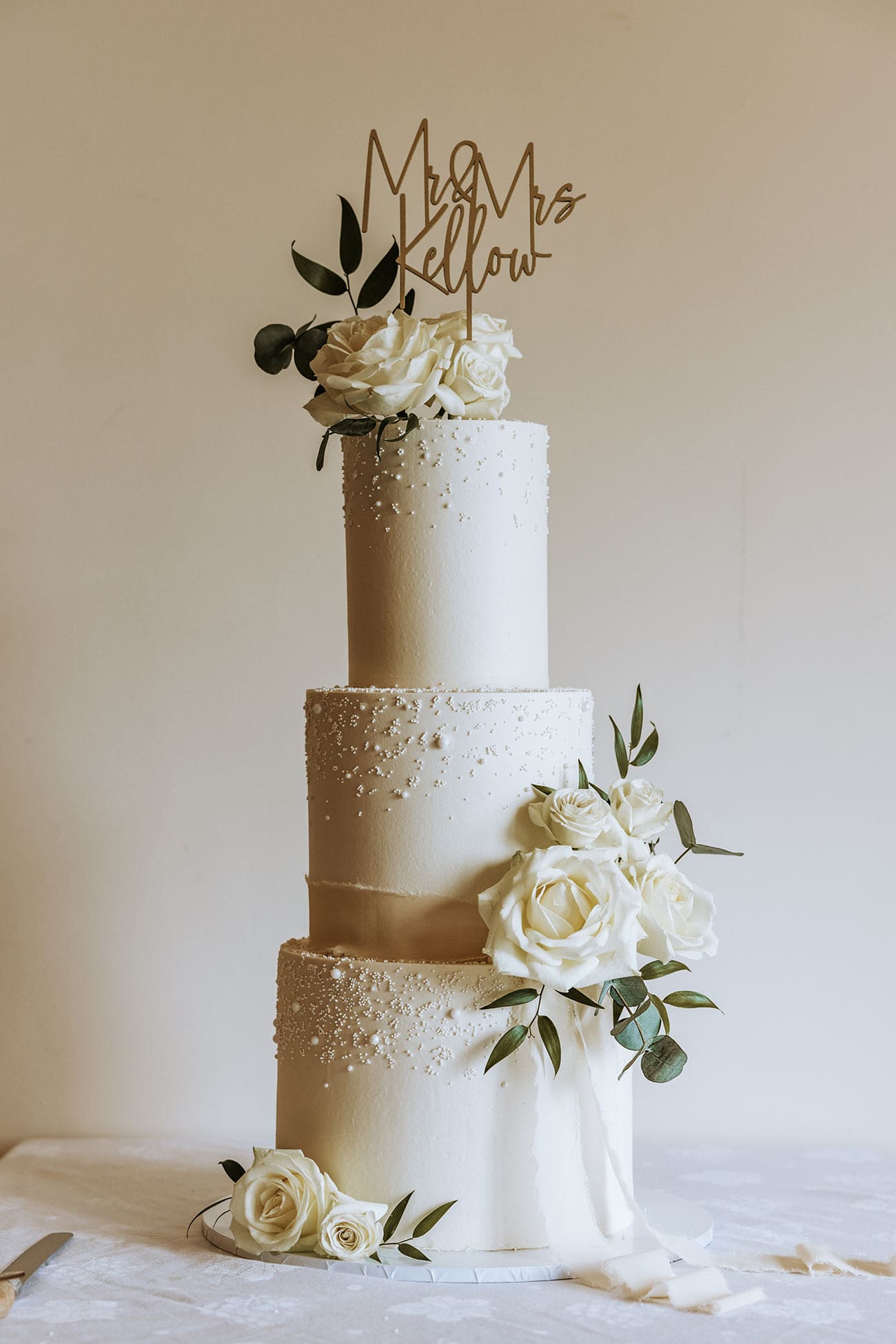 The three tiered wedding cake adorned with flowers