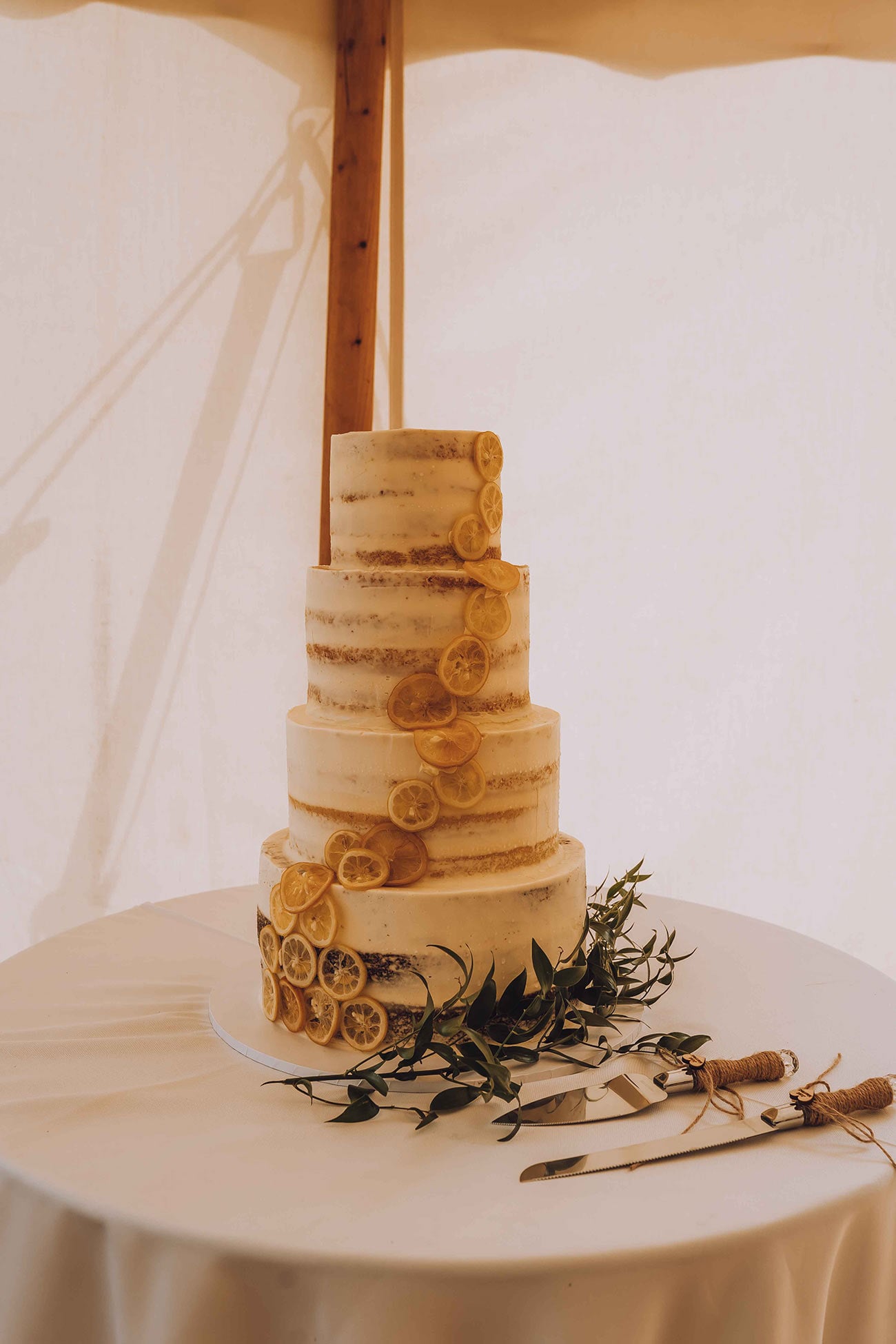 The three tiered wedding cake adorned with sliced lemons 