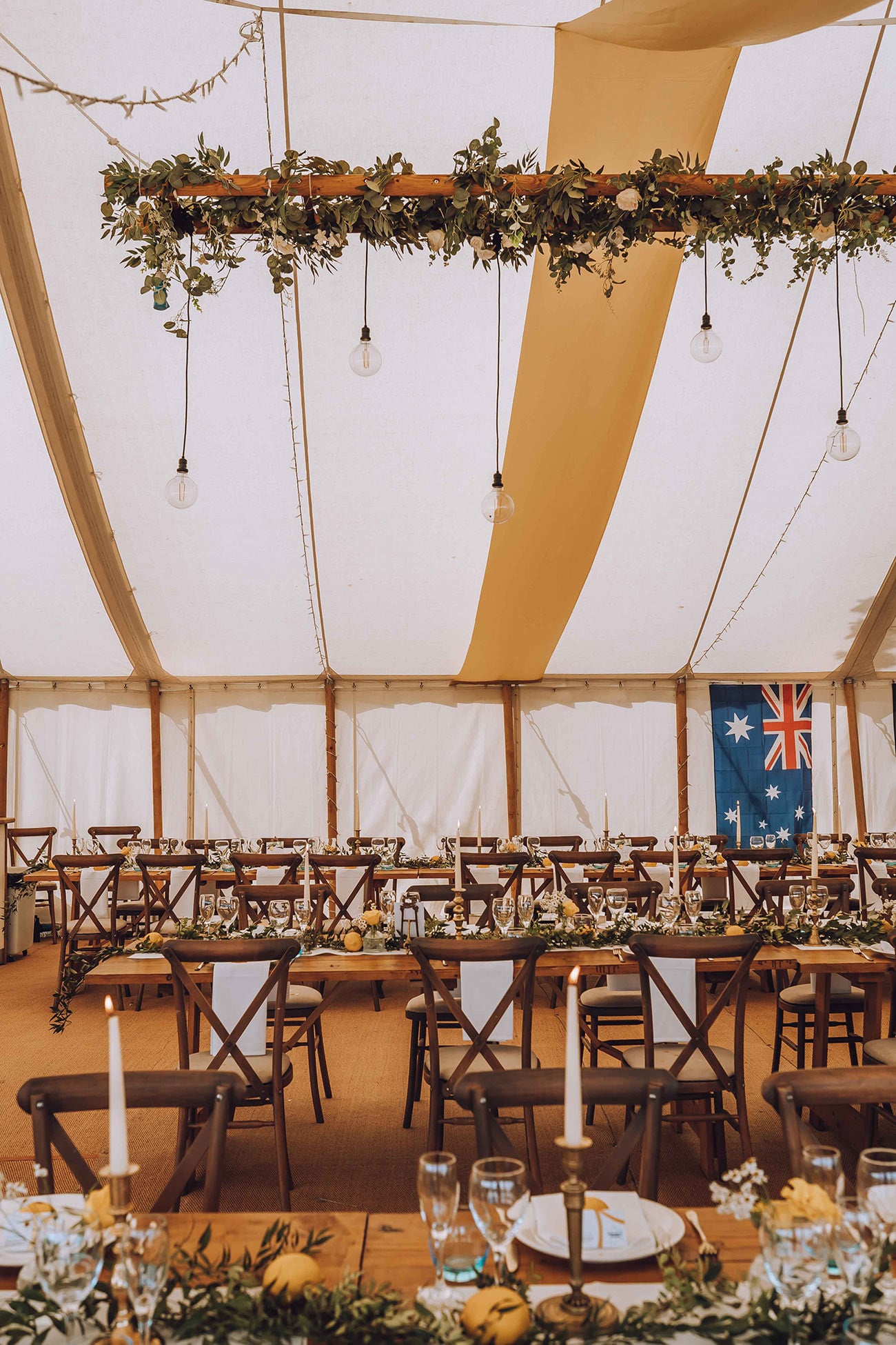 The wedding marquee ready for the reception with laid out tables and the Australian flag hanging up