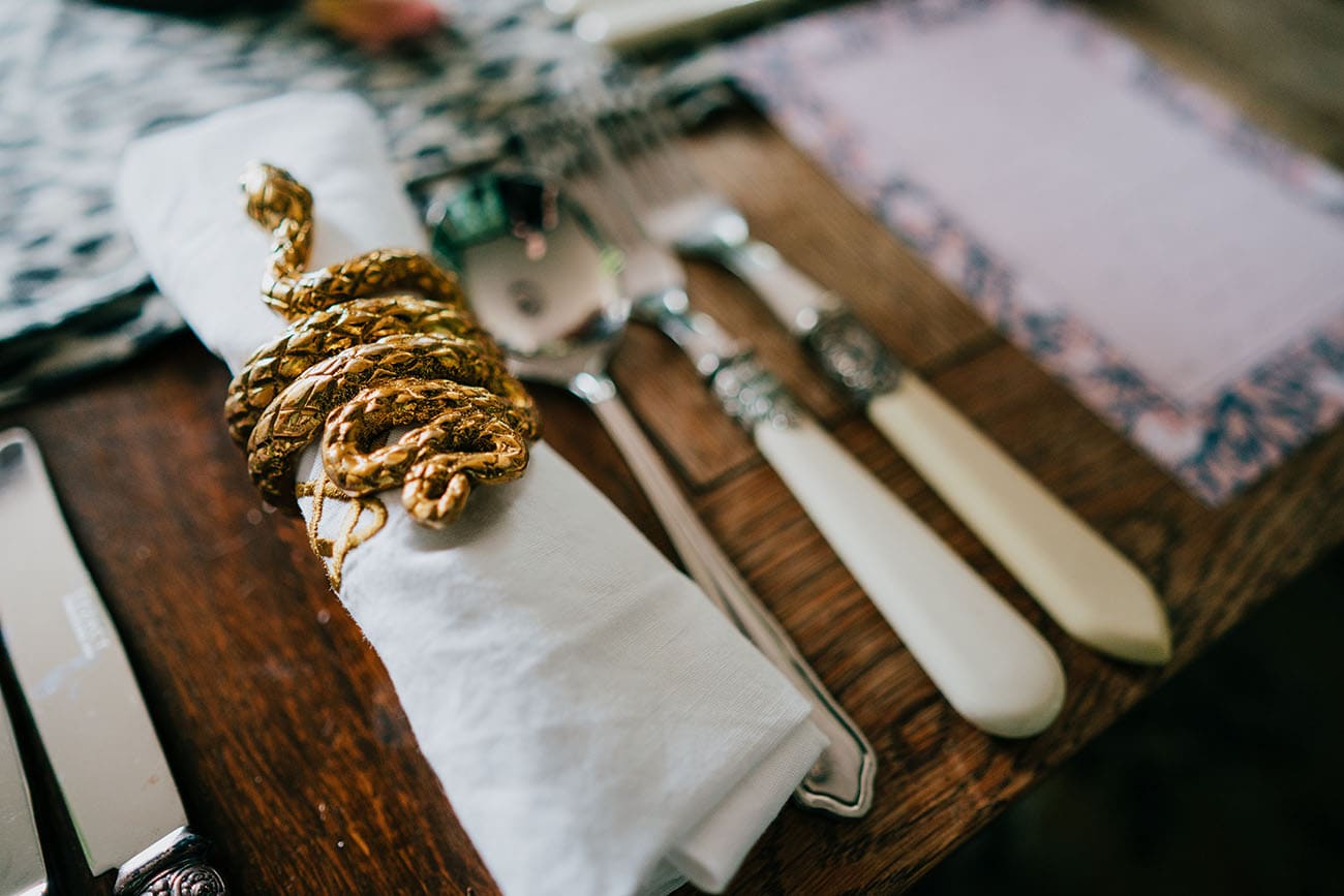 The serpent-shaped napkin rings sit aside the table settings