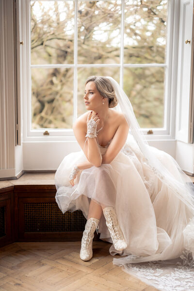 Bride sitting in a window