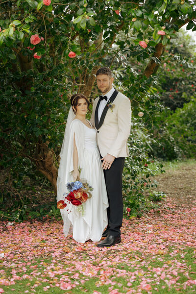Bride and Groom pose with flowers