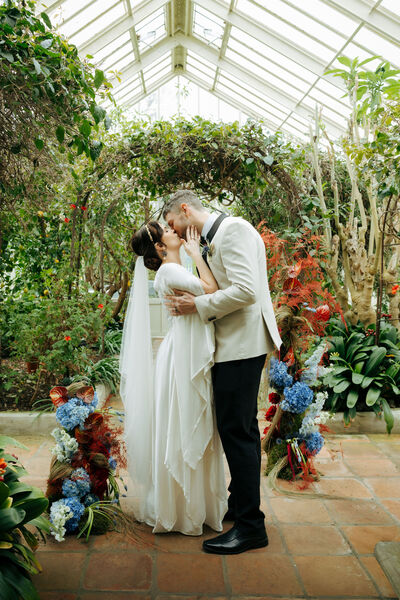 Bride and Groom with flowers in an indoor garden