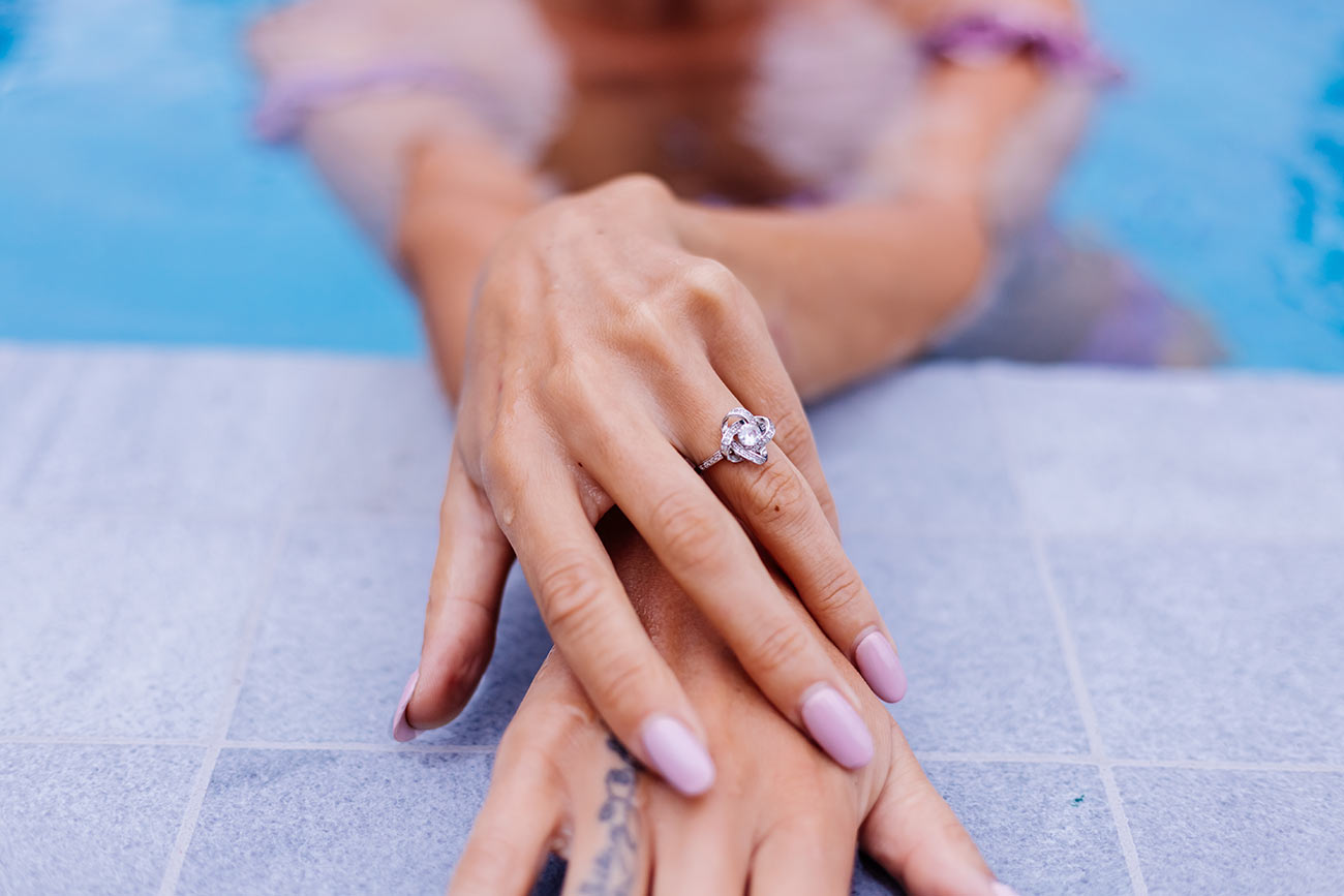 close-shot-womans-hands-edge-swimming-pool-with-ring-finger