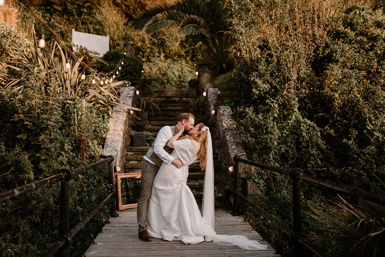 The bride and groom kissing in the beautiful surroundings