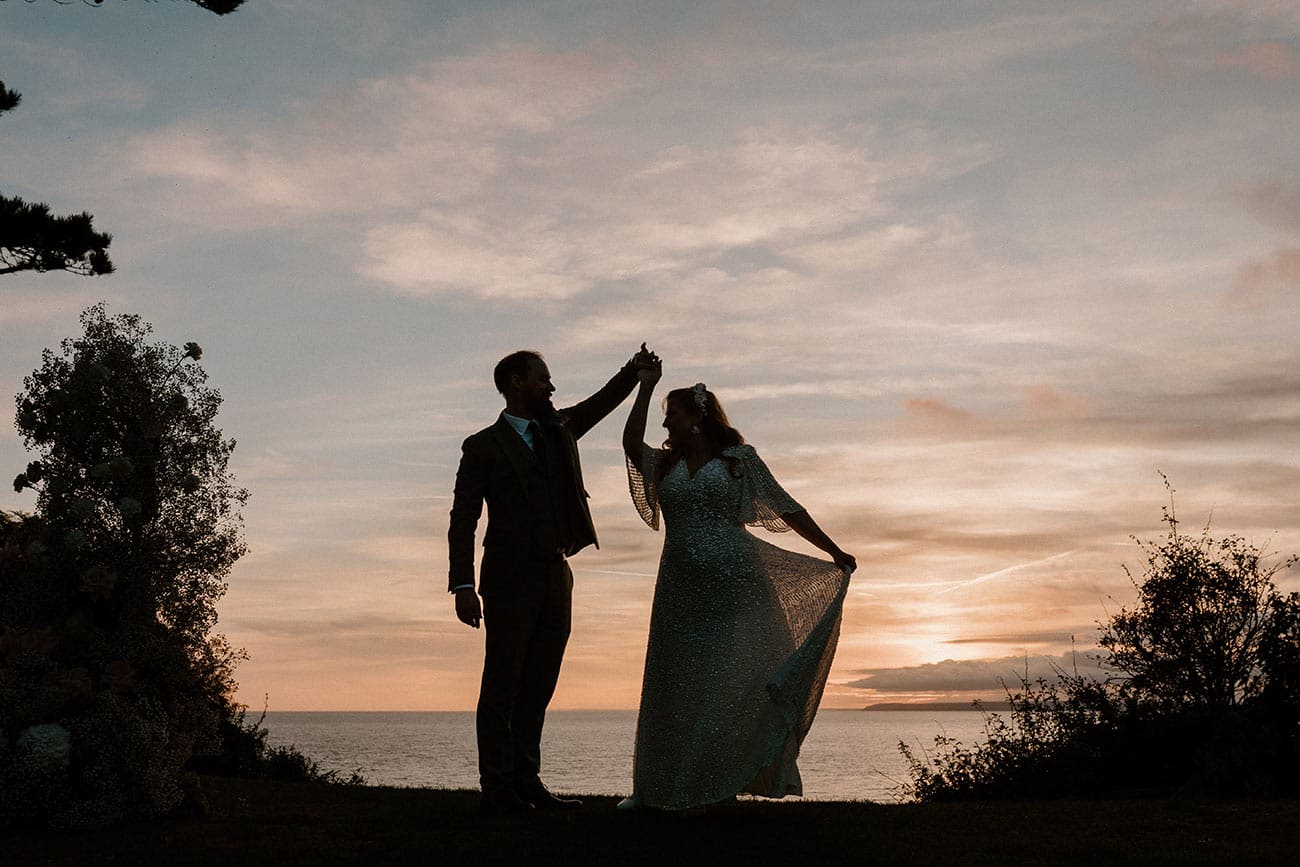 The bride and groom dancing outside in the beautiful sunset