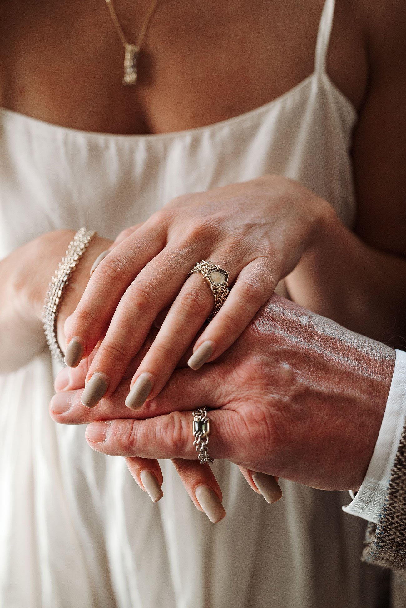Bride with hand over the groom showing their wedding rings