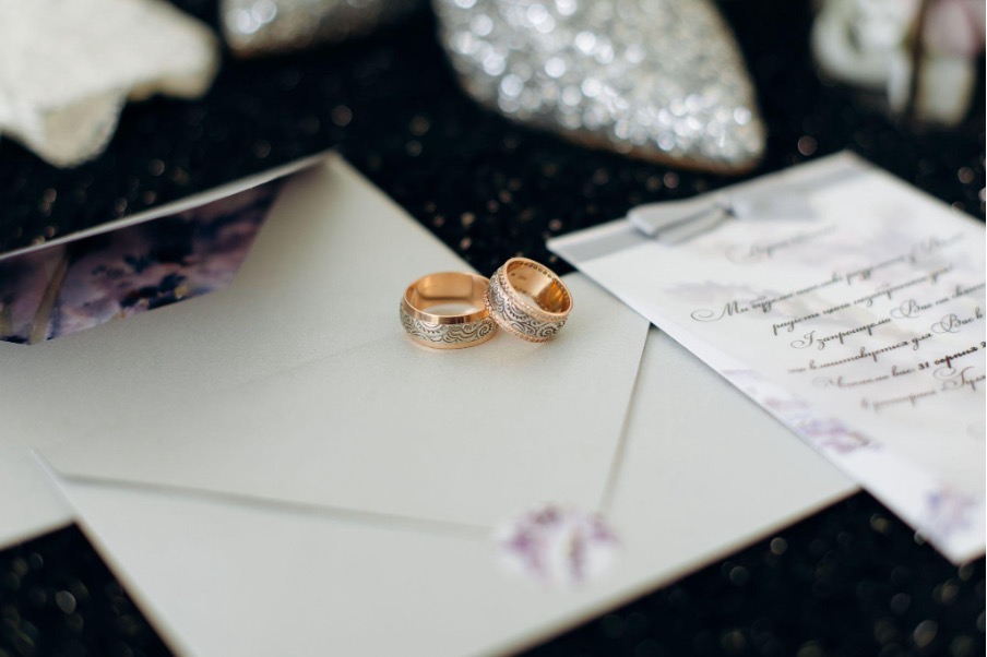 gold-wedding-rings-on-white-envelope