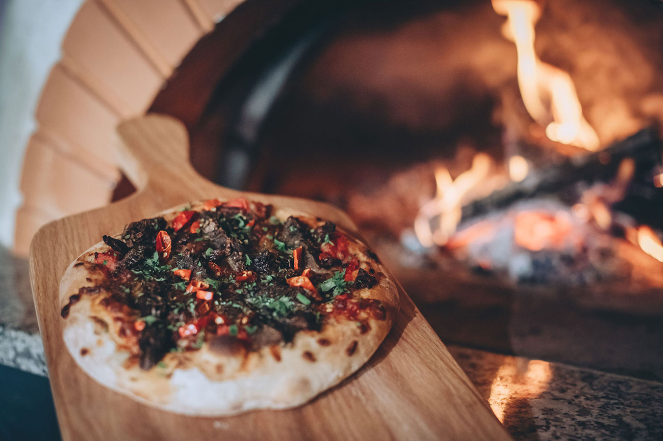 Pizza cooking on fire pit